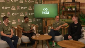 Cuatro participantes del Zoological Summit de Planet Zoo 2 conversan en el escenario de Chester Zoo.