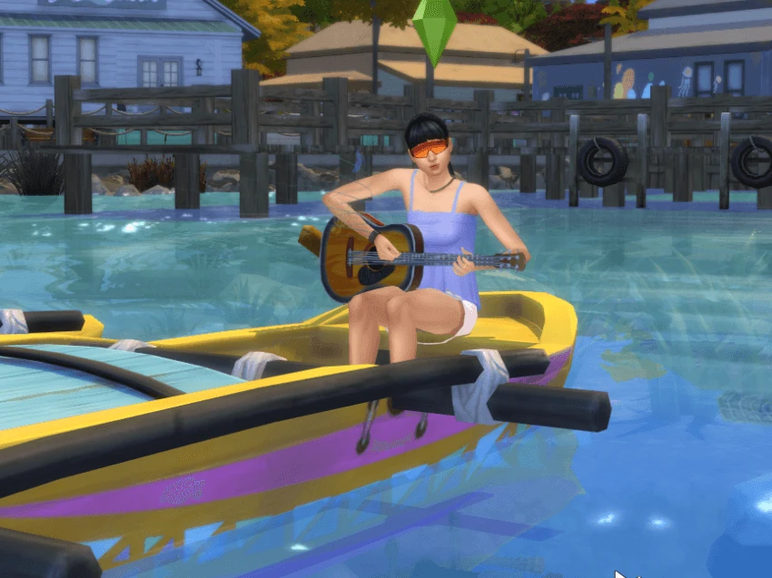 Una Sim toca la guitarra sentada en una embarcación amarilla sobre el agua.